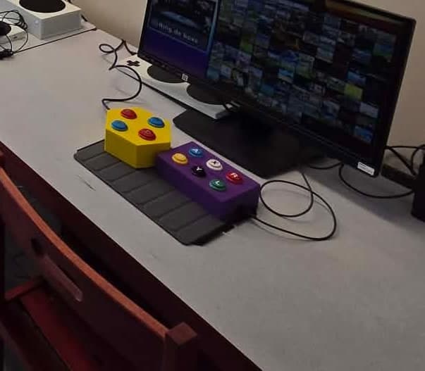 Deux boîtiers de commande jaune et violet avec des boutons colorés